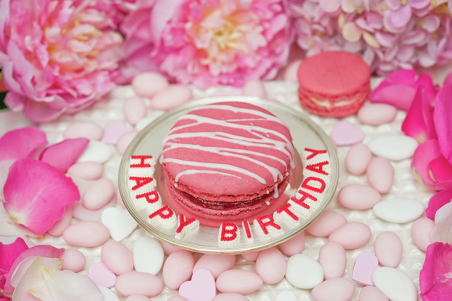 Pink Macaroon Striped With Icing On A Silver Plate, Surrounded By Sugared Almonds, Peonies And Rose Petals Photograph by Burgess, Jasmine