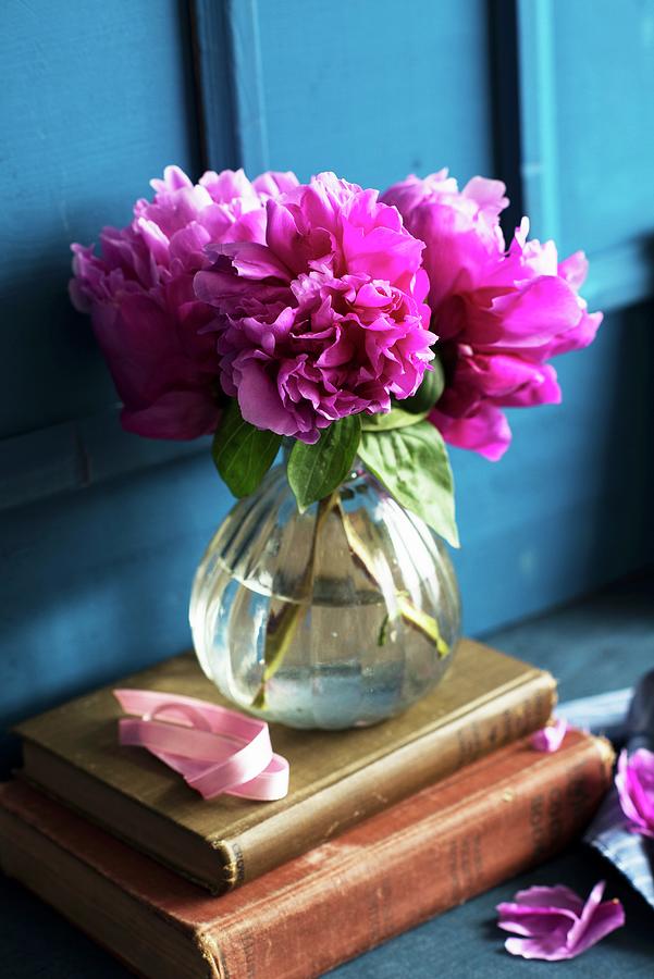 Pink Peonies In A Glass Vase On Antique Books Photograph by Veronika Studer