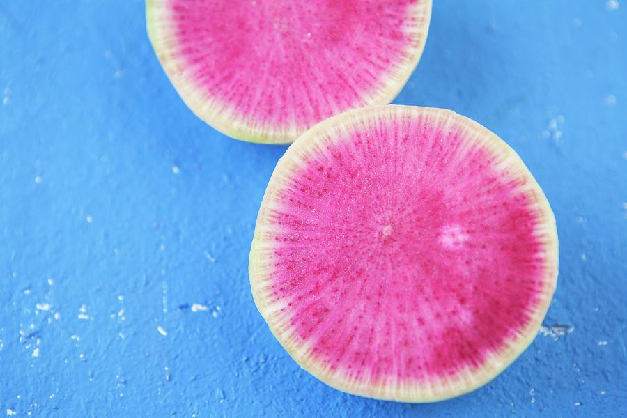 Pink Radish Slices On A Blue Surface close-up Photograph by Nika Moskalenko
