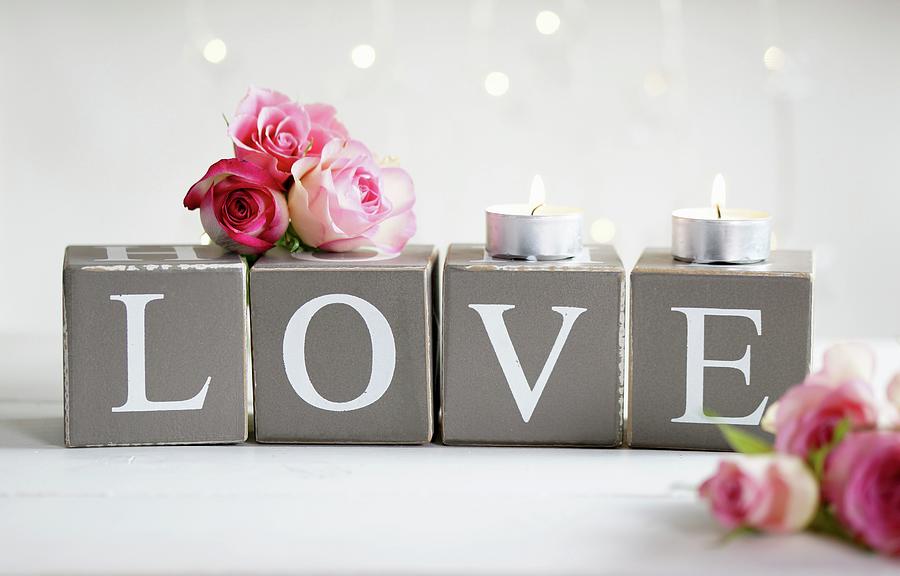 Pink Roses And Tealights On Cardboard Cubes Printed With Letters Spelling love Photograph by Angelica Linnhoff