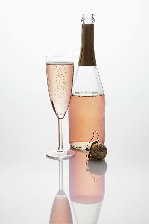 Pink Sparkling Wine bottle, Champagne Glass And Cork Photograph by Krger & Gross