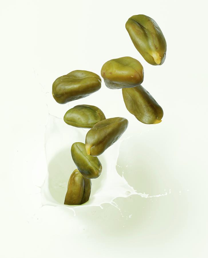 Pistachio Nuts Falling Into Pistachio Milk Photograph by Krger & Gross