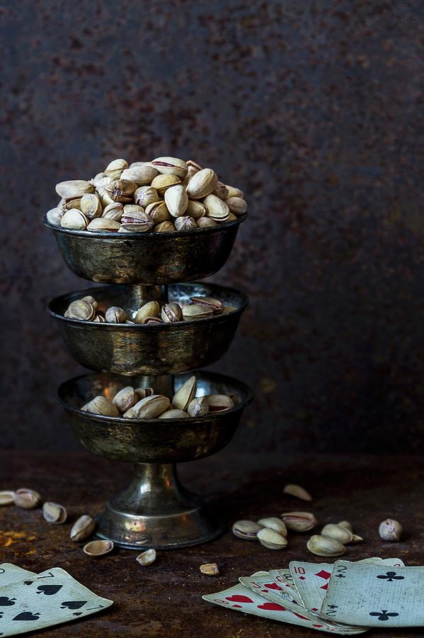 Pistachios On A Stand With Playing Cards Photograph by Adel Bekefi