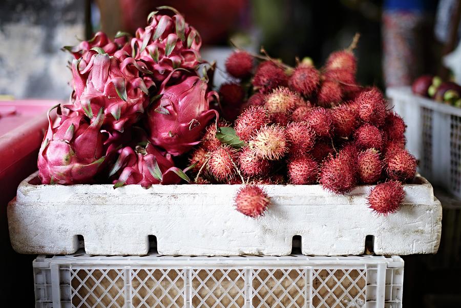 Pitahayas And Rambutans In Crates At A Market Photograph by Oliver Brachat