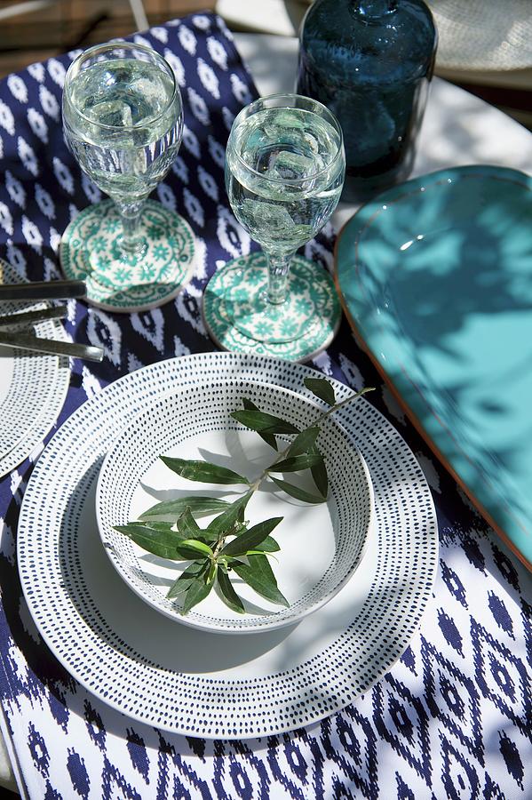 Place Setting With Blue And White Patterned Crockery, Olive Twig And Ikat Tablecloth Photograph by Winfried Heinze