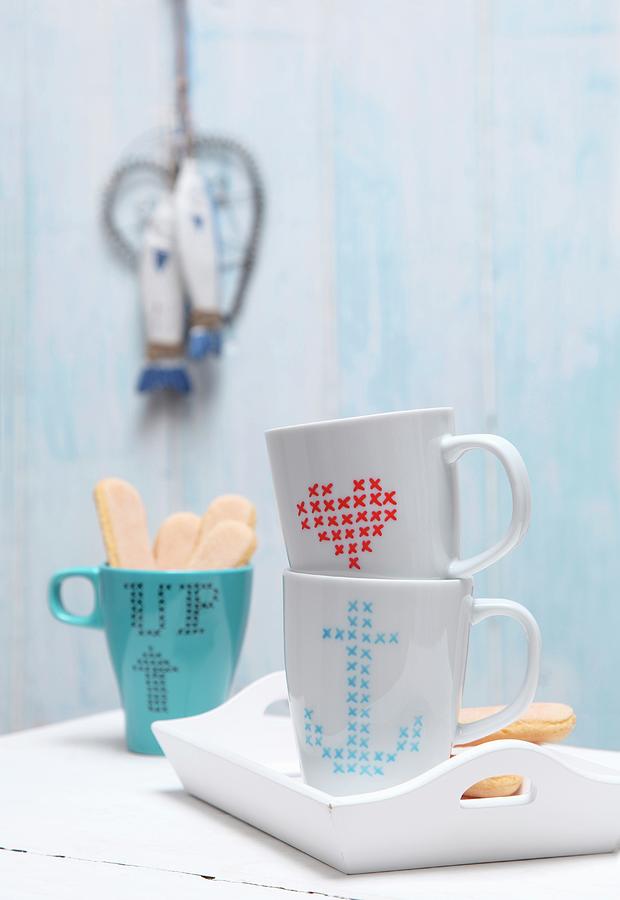 Plain Coffee Mugs Decorated With Cross-stitch Patterns Drawn On With Porcelain Pen Photograph by Thordis Rggeberg