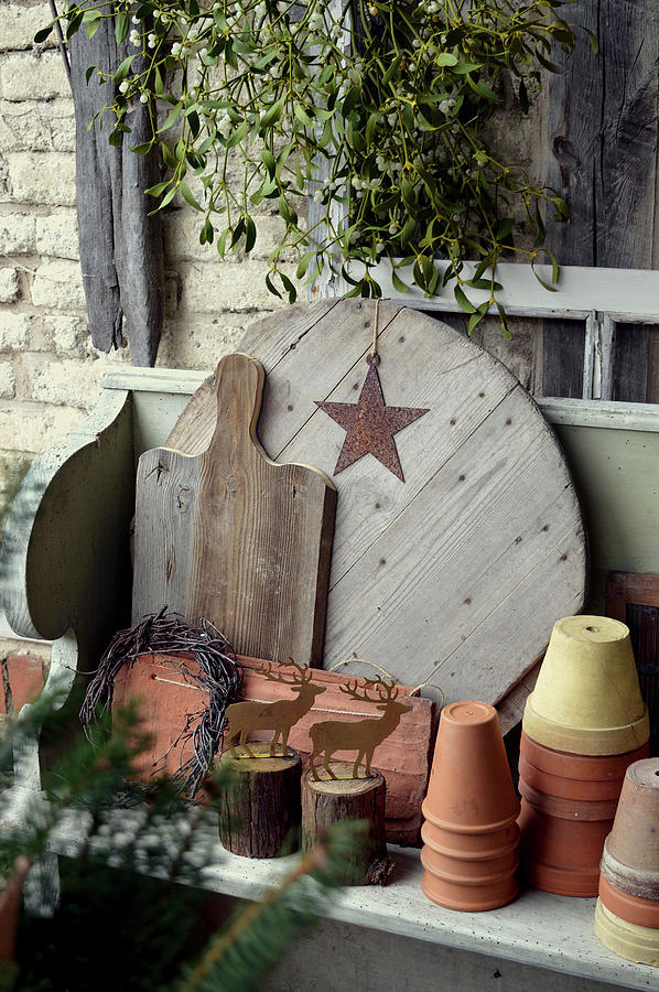 Plant Pots, Wooden Boards, And Metal Stags Arranged On Wooden Shelf Below Bunch Of Mistletoe Photograph by Christin By Hof 9