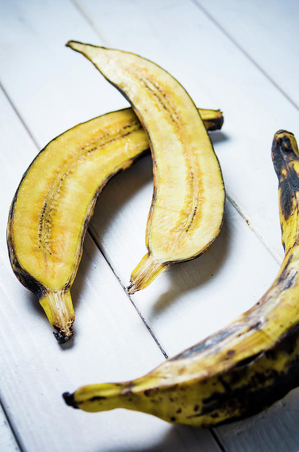 Plantain Cut In Half And Whole On A White Wooden Background Photograph by Giulia Verdinelli Photography