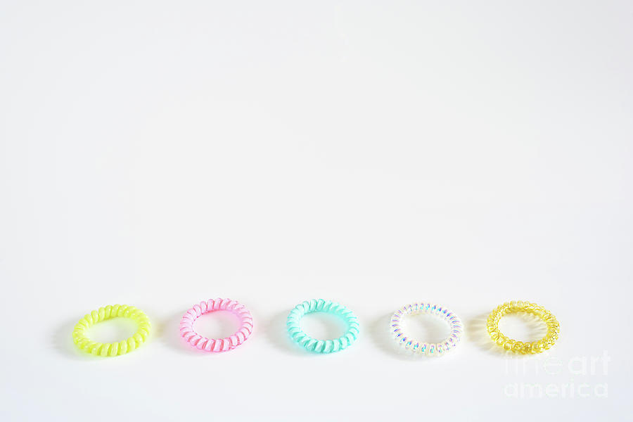 Plastic bracelets of various colors, isolated in a pattern arran Photograph by Joaquin Corbalan