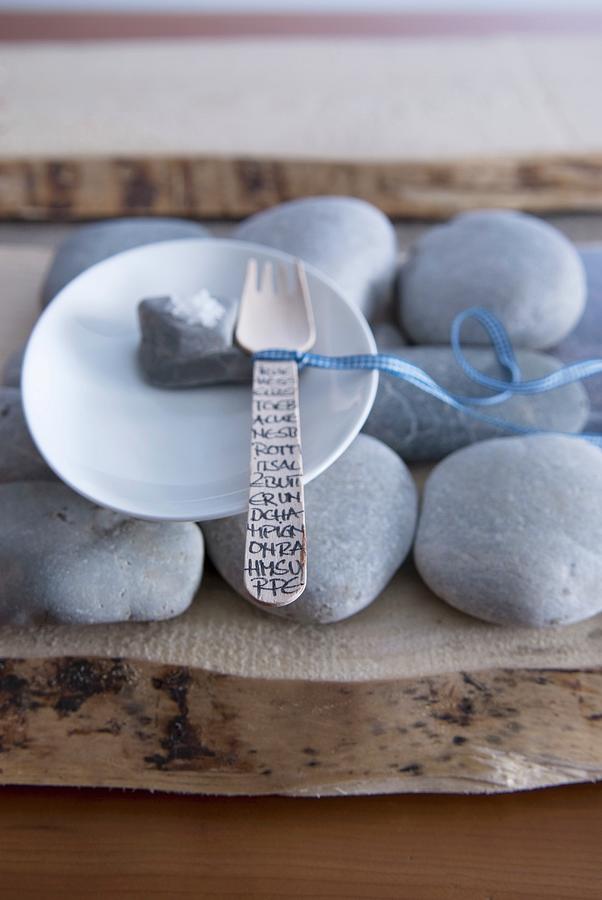 Plate And Wooden Fork On Pebble Placemat On Slice Of Tree Trunk Photograph by Matteo Manduzio