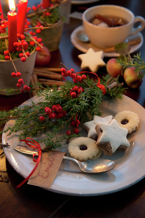 Plate Of Christmas Biscuits With Name Tag And Posy Of Holly Berries And Juniper Sprigs Photograph by Martina Schindler