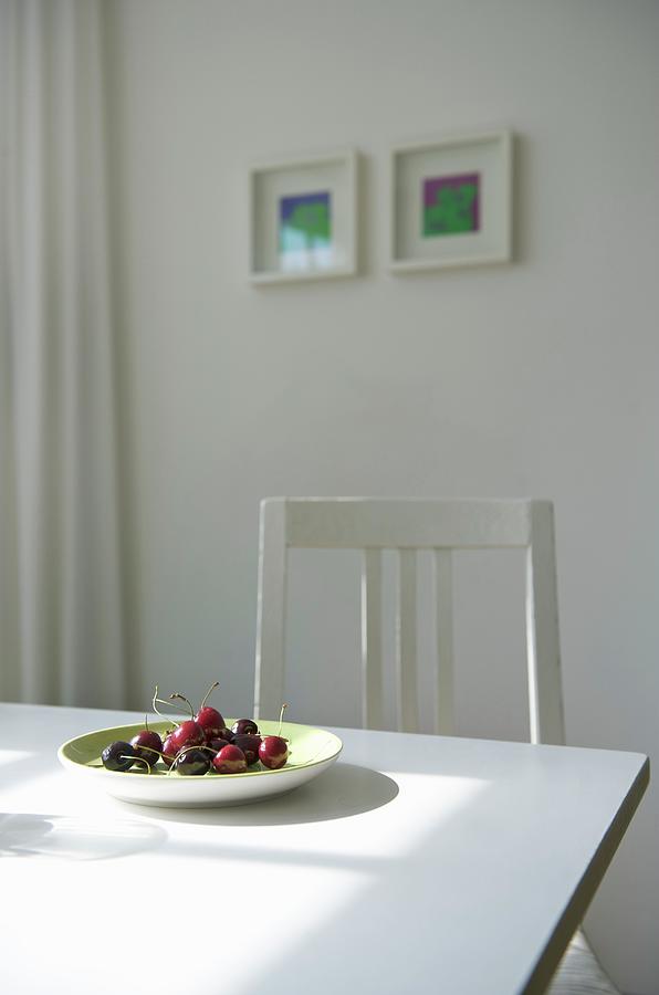 Plate Of Fresh Cherries On White Dining Table In Sunny Kitchen Photograph by Winfried Heinze