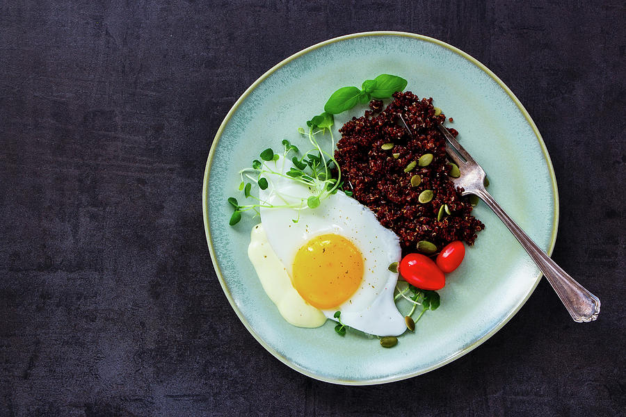Plate Of Red Quinoa With Fried Egg, Sprouts, Tomatoes And Pumpkin Seeds For Healthy Dinner On Dark Rustic Slate Background Photograph by Yuliya Gontar