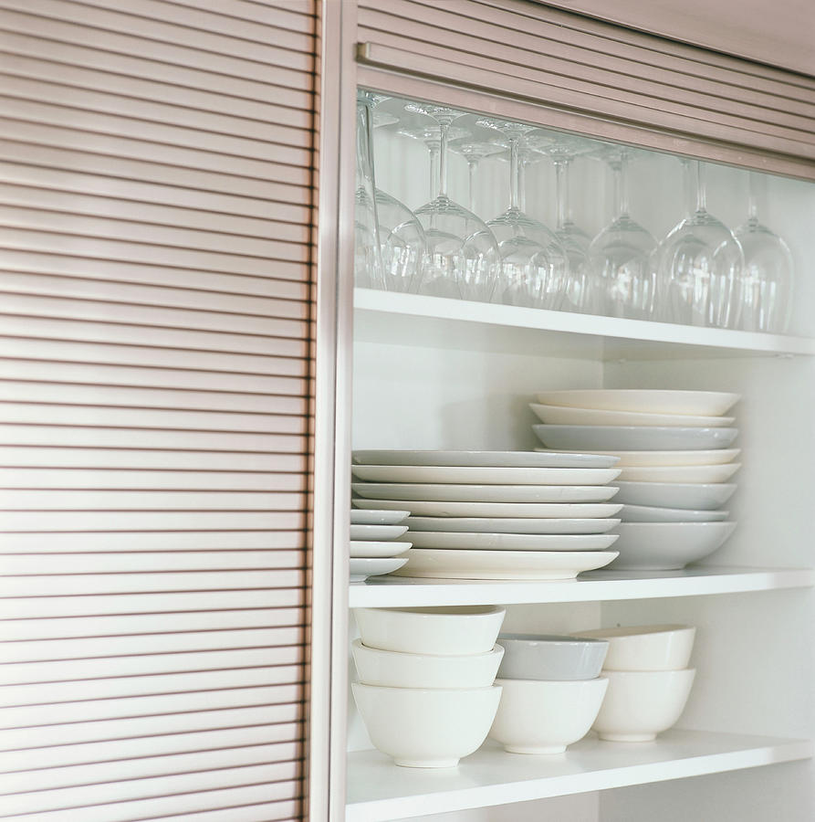 Plates And Glasses In A Kitchen Cupboard Photograph by Luc Wauman