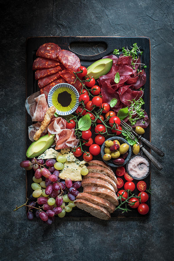 Platter With Olives, Cheese, Parma Ham, Chorizo, Ciabatta, Grapes, Avocado, Olive Oil, Pink Salt And Basil Photograph by Magdalena Hendey