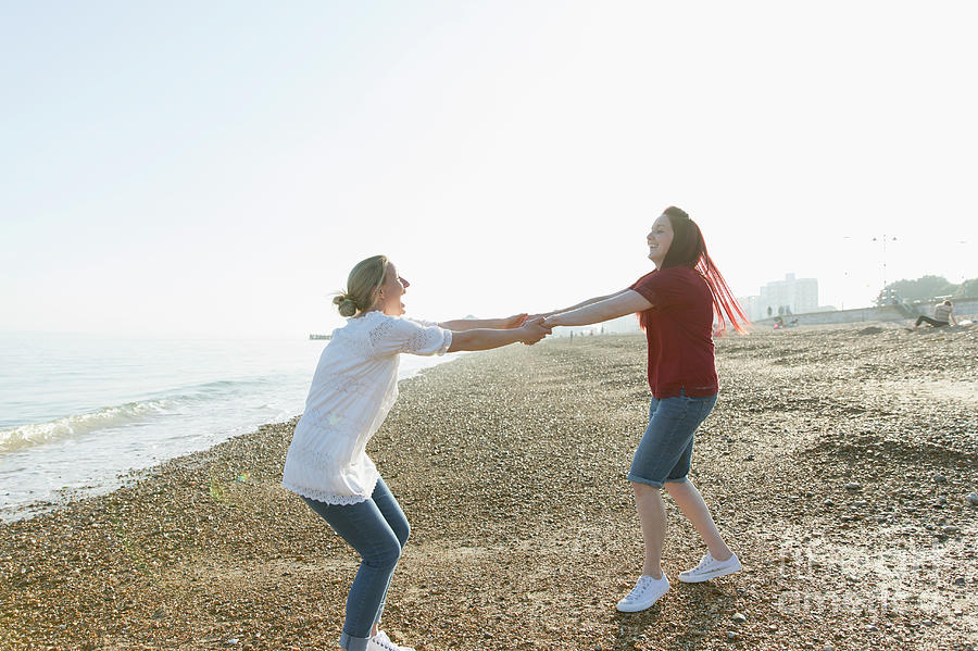 Playful Lesbian Couple Holding Hands And Spinning Photograph By Caia Imagescience Photo Library