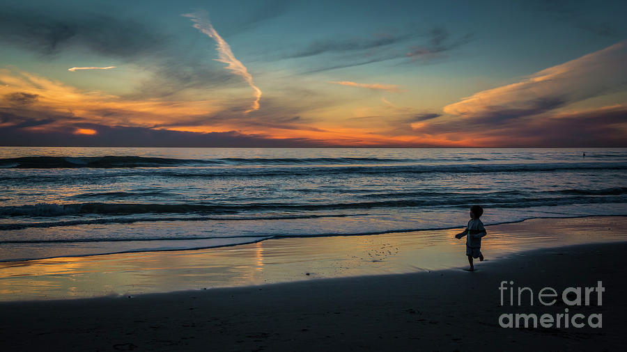Playing on a beach at sunset Photograph by Agnes Caruso