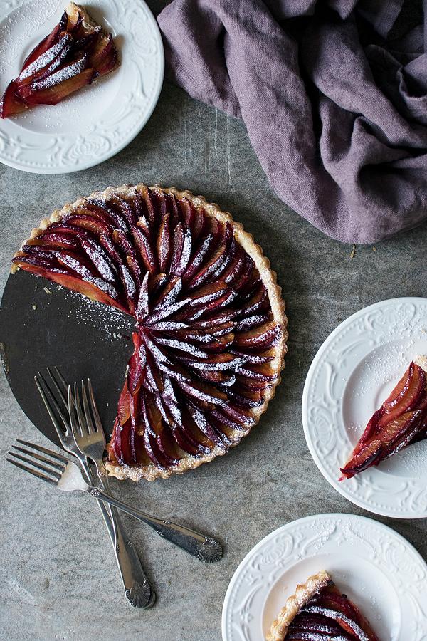 Plum Tart Dusted In Icing Sugar With Slices Cut Out Photograph by Justina Ramanauskiene
