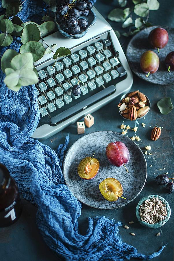 Plums, Grapes And Nuts In Front Of An Old Typewriter Photograph by Olimpia Davies