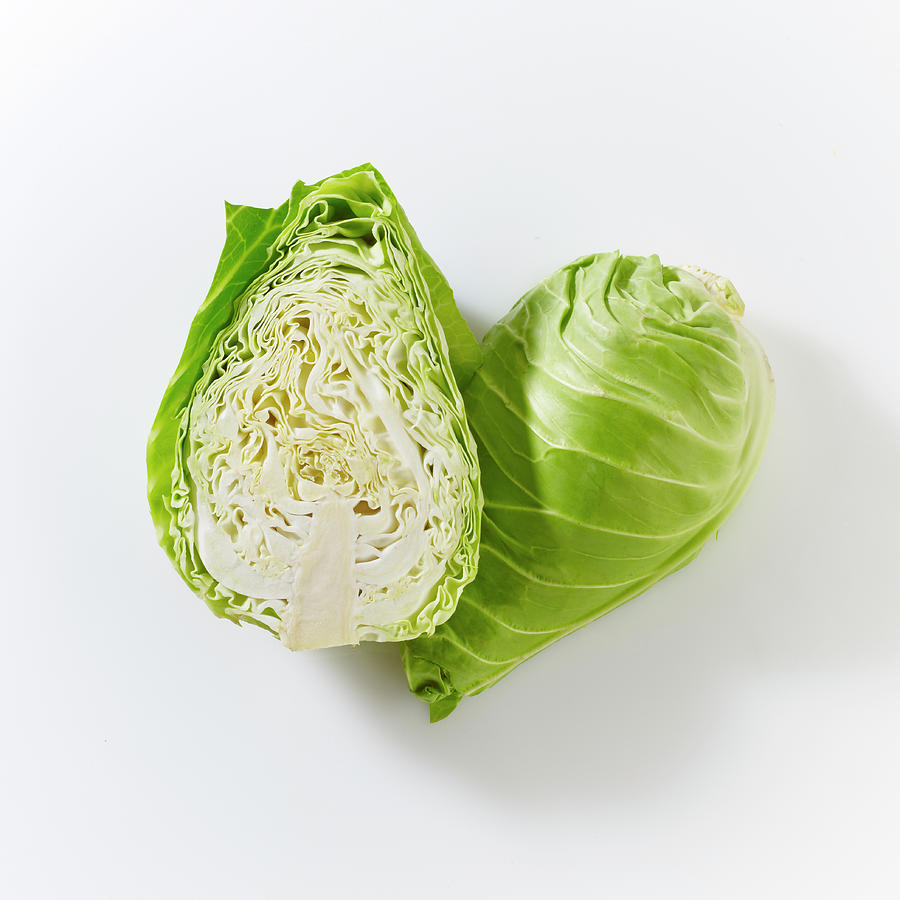 Pointed Cabbages, Whole And Halved, On A White Surface Photograph by Peter Rees