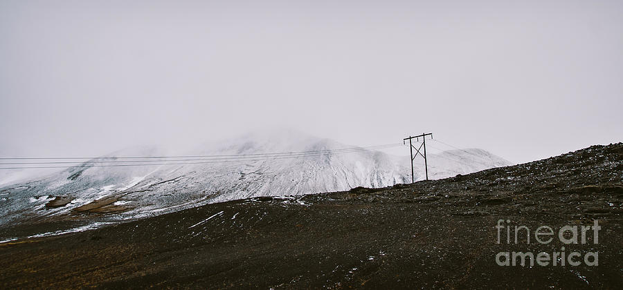 Poles of electricity in the middle of a snowy mountain to supply electrical power to remote villages. Photograph by Joaquin Corbalan
