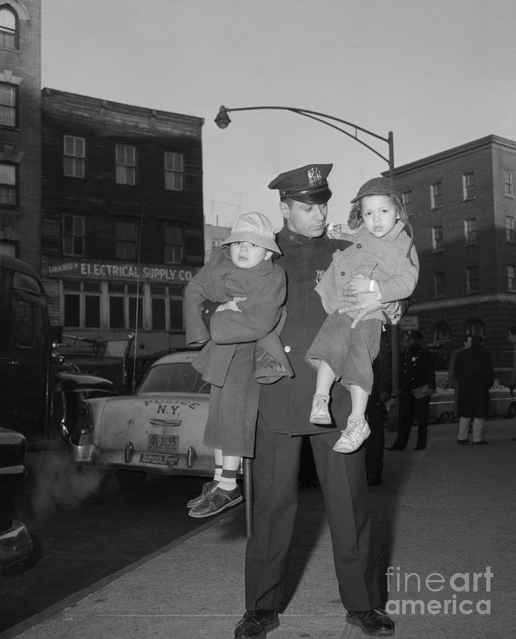 Police Officer Carrying Children Photograph by Bettmann
