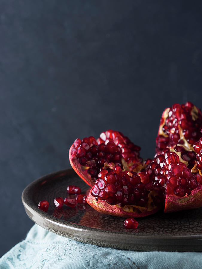 Pomegranate On A Gray Dish On Black Background Photograph by Sofya Bolotina