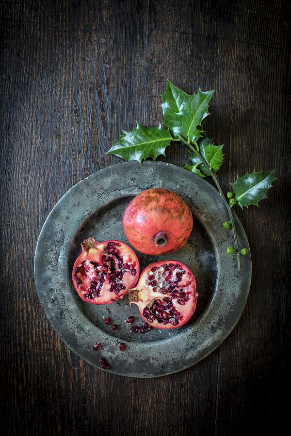 Pomegranates And A Sprig Of Holly Photograph by Helen Cathcart
