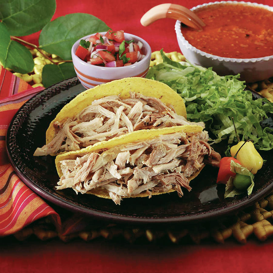 Pork Carnitas In A Crispy Corn Taco Shell Garnished With Tomatillo, Peppers, Shredded Lettuce