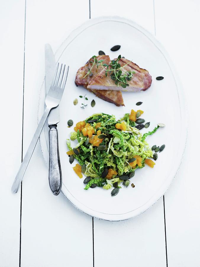 Pork Chop With A Green Kale And Orange Salad Photograph by Mikkel Adsbl