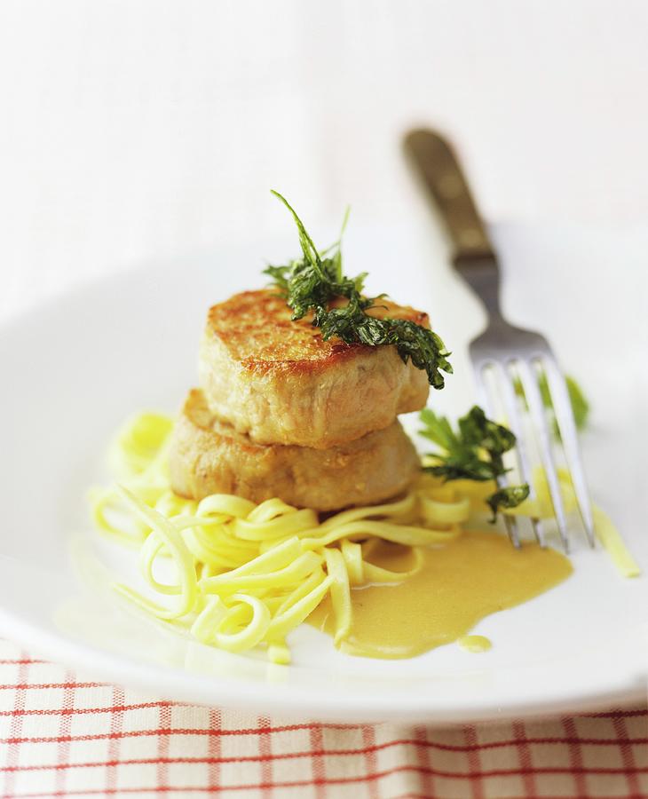 Pork Medallions With A Creamy Sauce On Ribbon Pasta Photograph by Michael Wissing