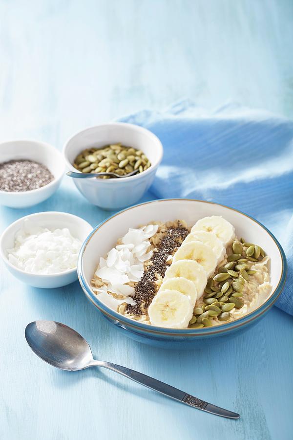 Porridge With Bananas, Pumpkin Seeds, Chia Seeds And Coconut Flakes Photograph by Olga Miltsova