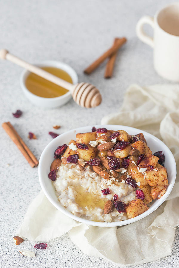 Porridge With Caramelised Apples, Almonds, Cranberries, Cinnamon And Honey Photograph by Malgorzata Laniak