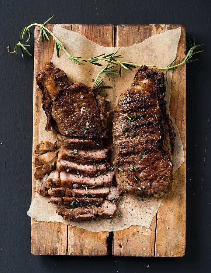 Porterhouse And Sirloin Steaks On A Wooden Board Photograph by Great Stock!