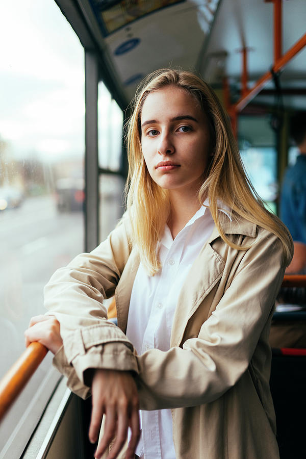 Transportation Photograph - Portrait Of A Woman In A Coat And White Shirt Standing Inside The Bus by Cavan Images / Sashunita