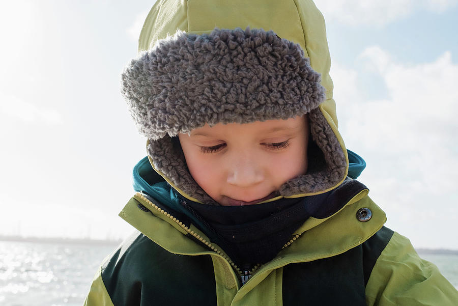 Portrait Of A Young Boy Wrapped Up Warm At The Beach In Winter ...