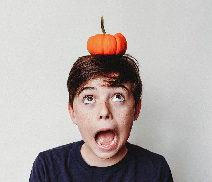 Portrait Of An Excited Boy Balancing A Small Pumpkin On His Head ...