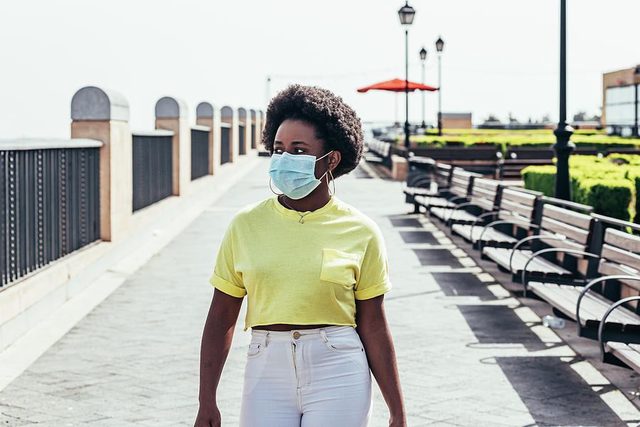 Space Photograph - Portrait Of Black Girl With Face Mask, Afro Hair And Hoop Earrings Walking Through An Urban Space. by Cavan Images