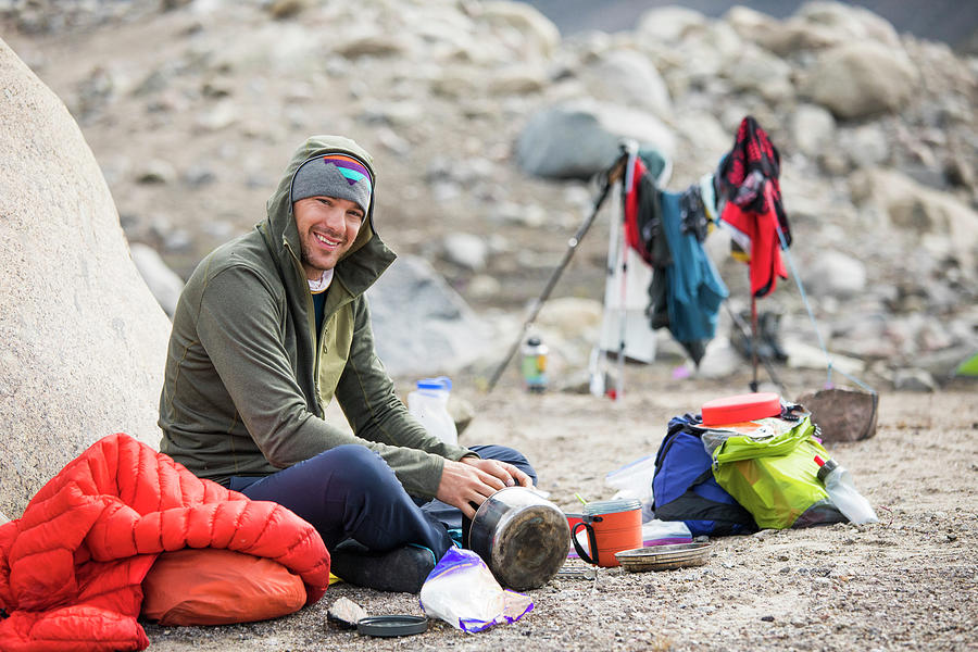 Portrait Of Climber Sitting Down For A Meal At Camp. Photograph by ...