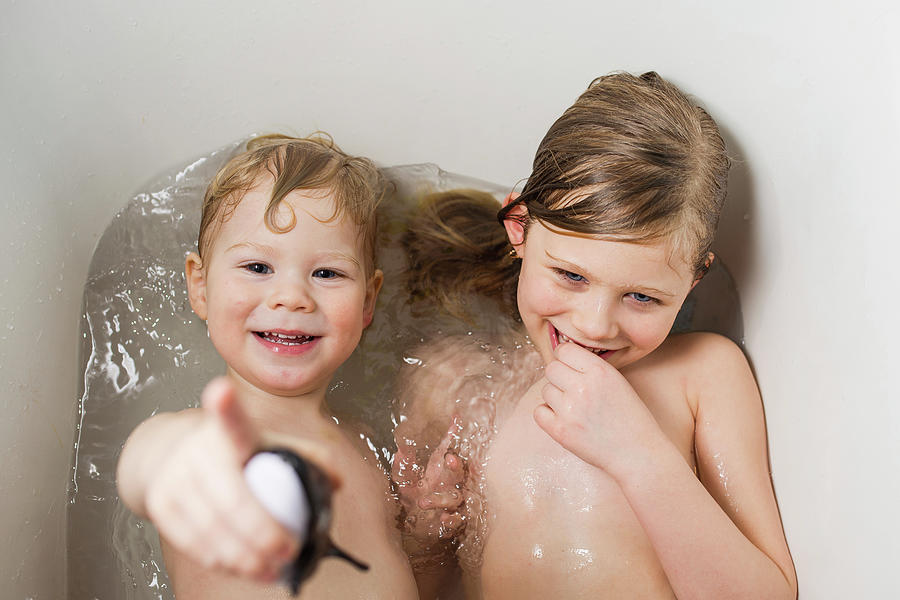 Portrait Photograph - Portrait Of Happy Brother With Sister Bathing In Bathtub At Home by Cavan Images