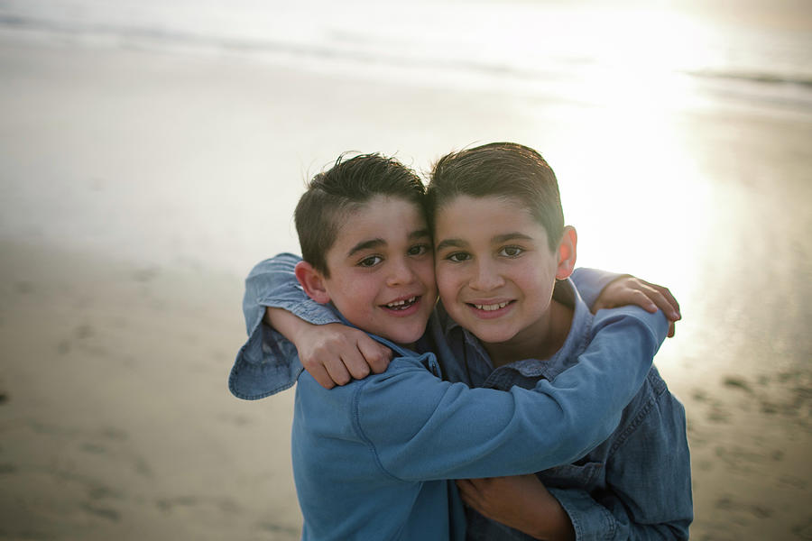Sunset Photograph - Portrait Of Happy Brothers Standing At Beach During Sunset by Cavan Images