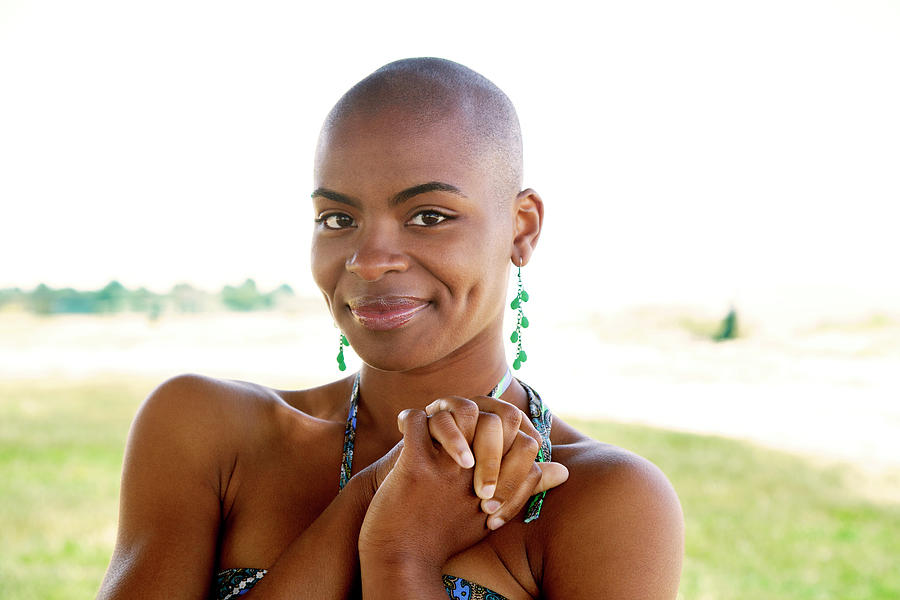 Portrait Of Happy Shaved Head Woman Standing With Hands Clasped On