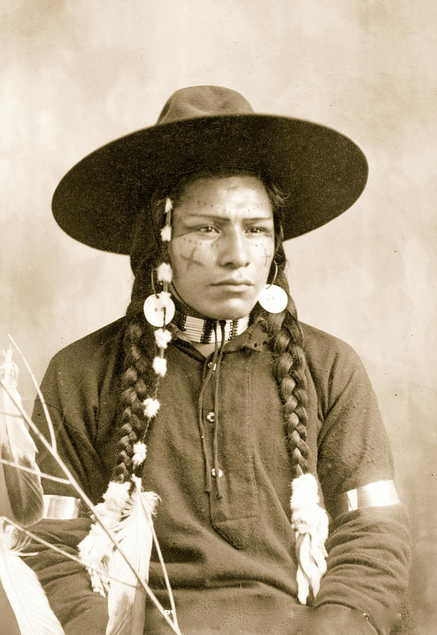 Portrait of Indian with decorated face, feather and bead ornaments ...