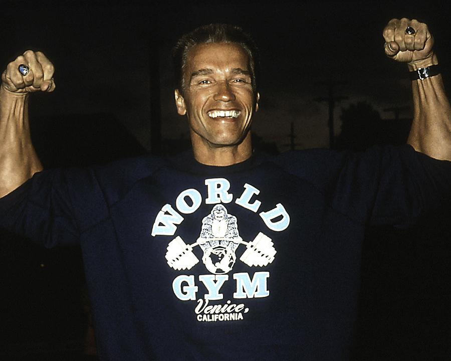 Arnold Schwarzenegger Photograph - Portrait Of Smiling Arnold Schwarzenegger Flexing His Muscles by Globe Photos