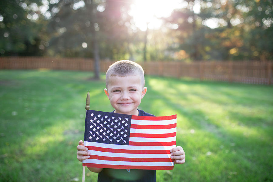 Portrait Of Smiling Boy Holding American Flag While Standing On Field ...