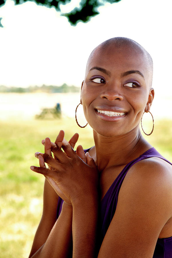 Portrait Of Smiling Shaved Head Woman Standing With Hands Clasped