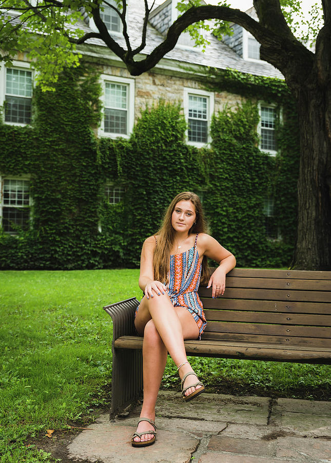 Portrait Of Woman Sitting On Bench Against Building At Park Photograph ...