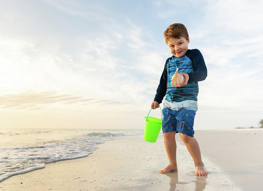 Portrait Of Young Boy With Cute Expression Holding A Seashell ...