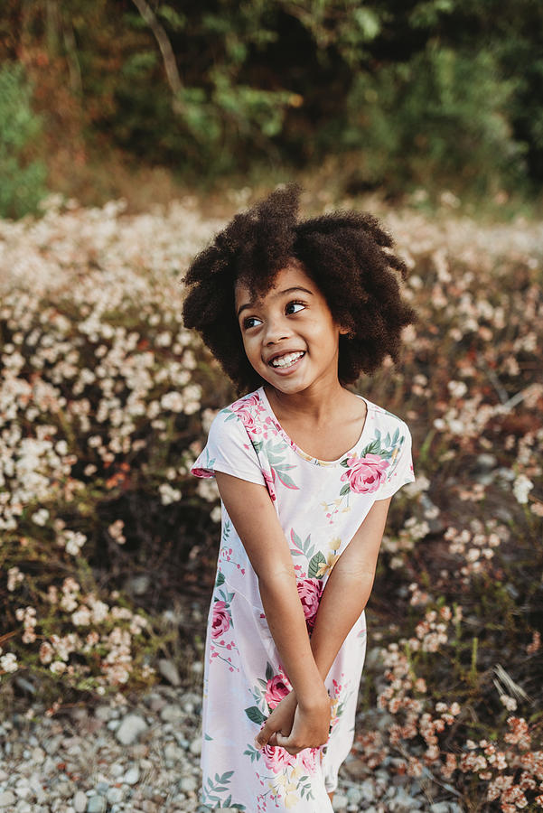 Portrait Of Young School-aged Girl Smiling In Field Of Flowers ...