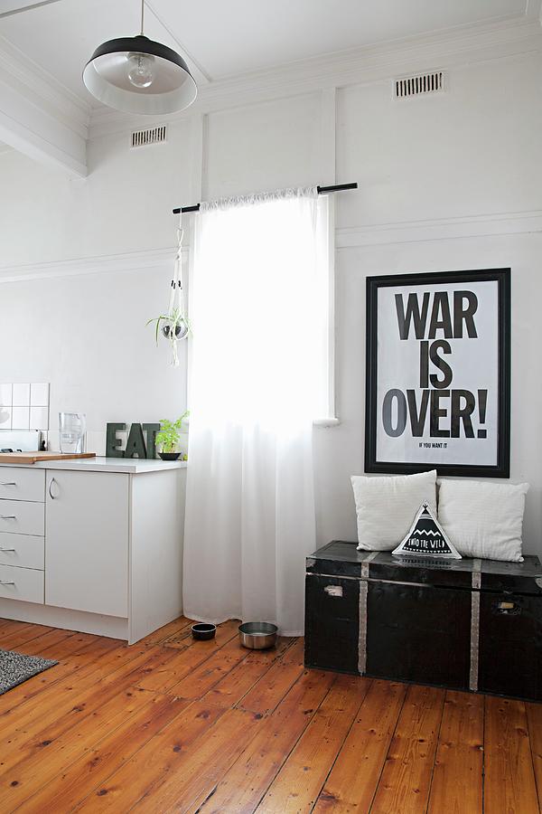 Poster With Motto Above Vintage Trunk Next To Window And Simple Kitchen Counter In Period Apartment Photograph by Natalie Jeffcott